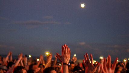 Cheerful crowd cheering. Hands up. Silhouette, night, evening event