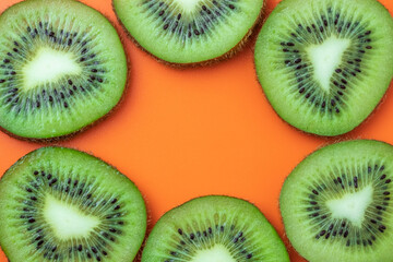 Kiwi fruit, tropical frame, food texture. Mockup with empty space, copy space for text. Summer background, orange pattern.