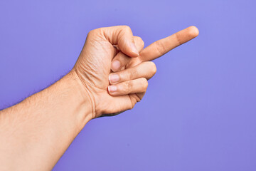 Hand of caucasian young man showing fingers over isolated purple background showing provocative and...