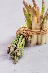 Green and white fresh asparagus on a gray background