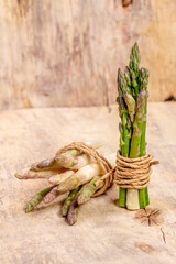 Green and white fresh asparagus on a wooden background