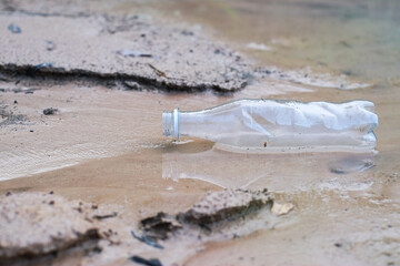 Waste from plastic bottle floating on the water surface in coast is a problem and water pollution close-up.