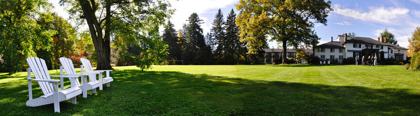 Fototapeta na wymiar Jacksons Point, Ontario / Canada - 10/11/2008: The panorama view of the tourist resort in Ontario, Canada with the Muskoka chairs on the lawn.