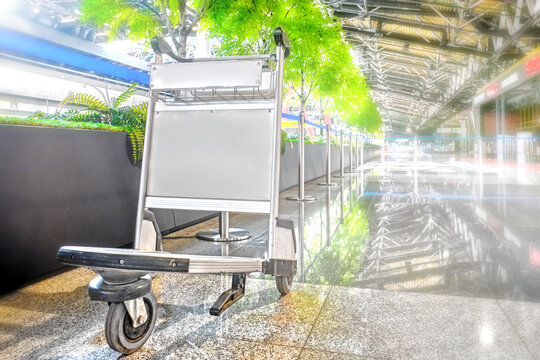 Empty Airport Interior Terminal With Abandoned Luggage Cart Against Blurred Background. Inside View Of Closed Airport Public Space Due To Global Coronavirus Outbreak. Airport Ceased Travel Operations