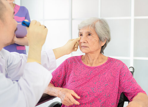 Doctor Use Flashlight Screening Eyes Of Old Asian Patient, Vision And Cataract Screening, Elderly Healthcare Check Up In Hospital