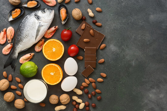 Food allergens. Seafood, milk, chocolate, nuts, citrus fruits, eggs. Allergic food concept. Top view, flat lay, copy space.