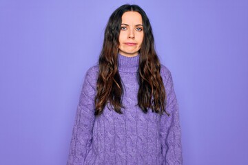 Young beautiful woman wearing casual turtleneck sweater standing over purple background depressed and worry for distress, crying angry and afraid. Sad expression.