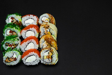Large set of Delicious sushi rolls view. A lot assortment Philadelphia roll Dishes from Japanese raw fish in one plate in traditional restaurant. Japan food menu service