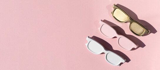 Colored sunglasses from the sun on a pink background. Creative concept.