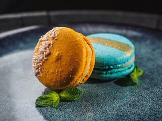 Color macaroons with mint on the blue plate