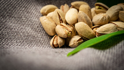 Pistachio nuts on a green tropical leaf. Tropical background, walnut.