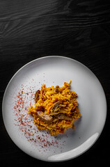Rice with Vegetables and Meat in white plate on black wooden table background