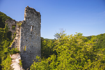 Fototapeta na wymiar Forsaken, old, stone castle ruins on Tepec hill, overlooking town of Samobor beneath, standing above dense forest surrounding nearby hills