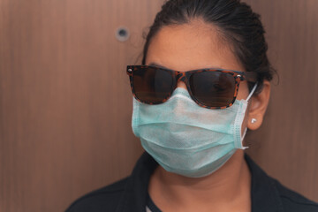 Young woman wearing surgical mask during the pandemic situation.