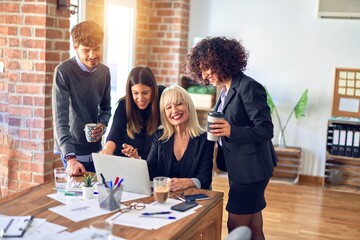 Group of business workers smiling happy and confident. Working together with smile on face  using laptop at the office