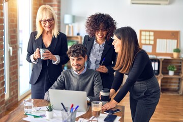 Group of business workers smiling happy and confident. Working together with smile on face  using laptop at the office