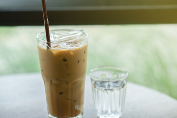 Iced coffee and cold water placed on the table