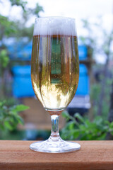 glass glass with cold beer on a warm evening in nature. beer on the background of a burning fire in the grill