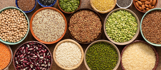 Assorted of a various of legumes, beans, grains and seeds in bowls, banner. Top view, flat lay, border