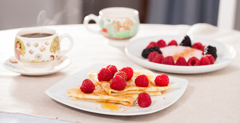 breakfast of pancakes with fresh raspberries on table