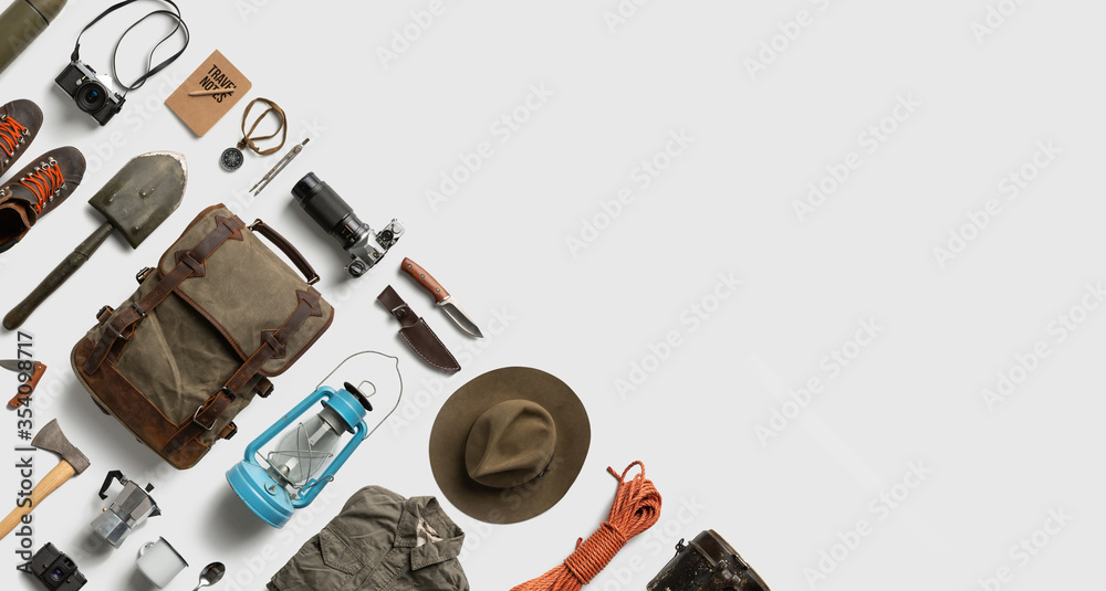 Wall mural top view of hiking and camping items arranged on abstract white background with empty space