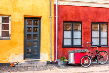 Fototapeta na wymiar Old red and yellow houses in the center of Copenhagen with typical bicycle. Old Medieval district in Copenhagen, Denmark
