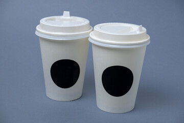 two mock up coffee to go cup on a gray background