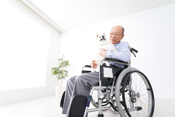 犬を飼う車椅子に乗った高齢の男性