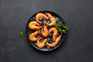Fresh raw shrimp with ice on a black stone background. Seafood. Top view with copy space.