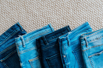 Flat lay of blue jeans of different shades on carpet. Blue casual denim jeans pattern with pockets. Everyday outfit concept and denim textile