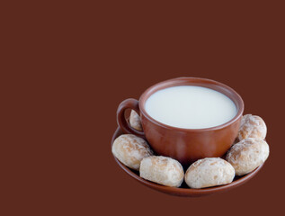 Cup with milk and vanilla gingerbread cookies on a plate
