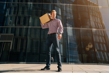 Young handsome sporty male guy standing in full length holds a paper box