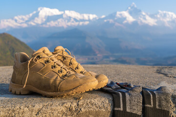 Tourist Hiking shoes with socks with Annapurna range snowy peaks on background. Mountain Trekking and Hiking, travel and tourism concept. Close-up stock photo.
