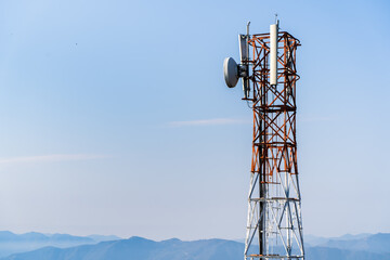 Telecommunication tower with antennas. Wireless Communication Antenna Transmitter with Mountains on...