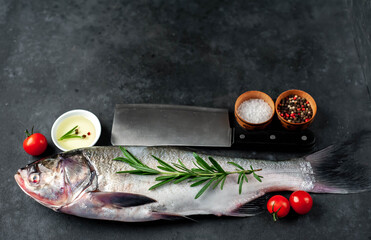 Fototapeta na wymiar raw silver carp fish with spices on a stone background