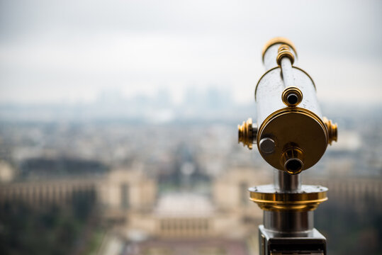 Eiffel Tower telescope overlooking for Paris. Old panoramic viewer or telescope on the Eiffel tower top. Monocular telescope at Eiffel Tower and view over the city.