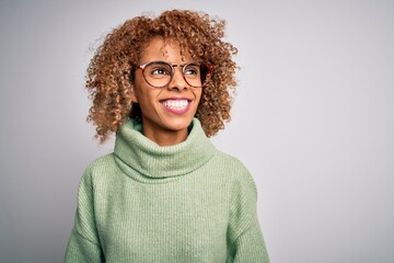 Young beautiful african american woman wearing turtleneck sweater and glasses looking away to side with smile on face, natural expression. Laughing confident. - Powered by Adobe