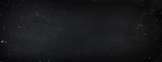 Black wall background with stucco pattern. Panoramic dark painted surface texture. Close up detail of raised surface