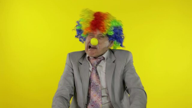 Elderly clown businessman entrepreneur boss making silly faces. Copy space