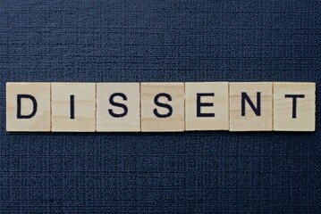 word dissent from gray wooden letters on a black table