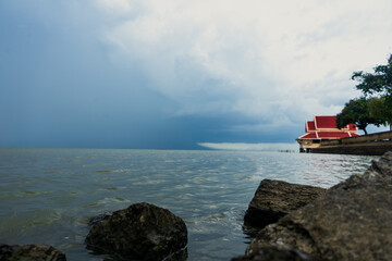 Red Thai style house in clear sky background : Phatthalung, THAILAND - July 8 , 2019 : King statue in beautiful sky at Lampam beach