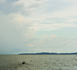 Fishing boat on brown colored lagoon with a beautiful sky in Thailand