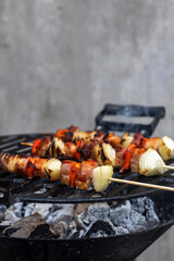 skewer with red pepper onion and smoked pork on a garden grill