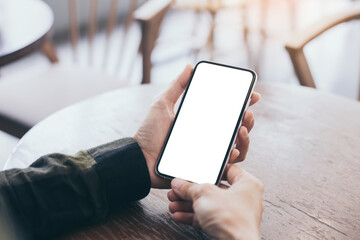 cell phone mockup image blank white screen.woman hand holding texting using mobile on desk at coffee shop.background empty space for advertise.work people contact marketing business,technology