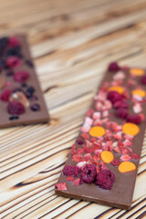 Obraz na płótnie Canvas different kinds of chocolate with dried fruits on a wooden board