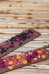 different kinds of chocolate with dried fruits on a wooden board