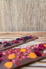 different kinds of chocolate with dried fruits on a wooden board
