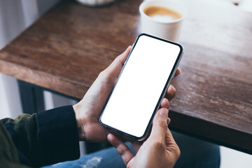 cell phone mockup image blank white screen.woman hand holding texting using mobile on desk at coffee shop.background empty space for advertise.work people contact marketing business,technology