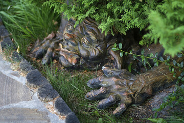 goblin garden sculpture under a bush