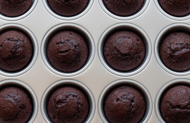 Close-up of baked chocolate muffins in iron baking dish. food background. horizontal image. view from above. selective focus